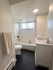 Modern bathroom with stylish black hexagonal floor tiles, white marble countertop, and sleek fixtures.