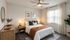 Cozy and stylish bedroom featuring a modern bed with elegant decor, warm natural lighting, and a lush indoor plant.