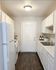 Bright and inviting galley kitchen with modern appliances, sleek white cabinets, and elegant hardwood floors.