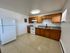Spacious kitchen with modern appliances, ample wooden cabinetry, and sleek countertops, perfect for culinary enthusiasts.