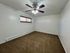Bright and spacious bedroom with fresh carpet, modern ceiling fan, and ample natural light.
