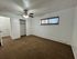 Bright and spacious bedroom with plush carpet, ceiling fan, and large window offering natural light.
