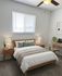 Cozy bedroom with modern decor, featuring a comfortable bed, elegant bedside tables, and a workspace under a ceiling fan.