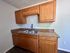 Charming kitchen with wooden cabinets, granite countertops, and modern dual sink.
