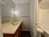 Modern bathroom with sleek countertop, large mirror, and classic wooden cabinetry.