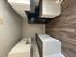 Modern kitchen featuring sleek dark countertops, white cabinetry, and elegant wood flooring.