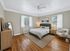 Bright and inviting bedroom with elegant hardwood floors, modern decor, and ample natural light.