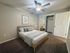 Cozy and modern bedroom with a stylish bed, soft grey walls, and inviting lighting, complete with a spacious closet and elegant decor.