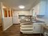 Modern kitchen with sleek countertops, white cabinetry, and stylish appliances. Cozy, open layout with inviting decor and natural lighting.