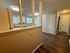 Charming apartment interior showcasing a bright kitchen, elegant wood flooring, and a cozy hallway with ample natural light.