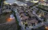 Charming aerial view of a well-lit apartment complex featuring multiple residential buildings and a relaxing pool.