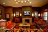 Elegant living room featuring a cozy fireplace, stylish orange and brown seating, and a captivating centerpiece under warm lighting.