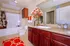 Elegant bathroom with warm tones, featuring a spacious tub, beautiful floral decor, and rich wood cabinetry.
