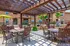 Charming outdoor patio with pergola shade, featuring elegant seating and lush greenery, perfect for relaxation.