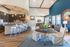 Elegant open-concept living area featuring modern kitchen with island seating, stylish pendant lighting, and cozy lounge space with vibrant accents.