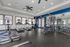 Modern fitness center with sleek treadmills, exercise machines, and large windows offering plenty of natural light.