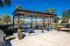 Charming outdoor patio with stylish wooden pergola, cozy seating, and serene water views, perfect for relaxation and entertaining.