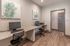 Contemporary home office with sleek granite desk, ergonomic chairs, and vibrant sea-themed artwork, perfect for productive remote work.