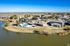 Charming residential community with a serene lakeside setting, featuring a sparkling pool and lush palm trees, offering a resort-style living experience.
