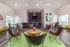 Modern and inviting communal space featuring stylish leather chairs, vibrant artwork, and a central wooden table, perfect for social gatherings.