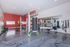 Modern fitness center with state-of-the-art equipment, including a punching bag, weight racks, and rowing machine in a sleek, well-lit space.