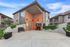 Inviting apartment entrance with modern architecture, lush greenery, and comfortable seating, showcasing a serene and welcoming atmosphere.