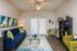 Contemporary living room with chic navy and lime green decor, stylish abstract art, and elegant glass coffee table, offering a warm and inviting atmosphere.
