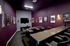 Chic in-home theater with luxurious seating, adorned with classic movie posters and ambient lighting for an immersive entertainment experience.