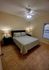 Inviting bedroom featuring a cozy double bed, stylish bedside lamps, and elegant tile flooring.