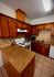 Elegant kitchen with rich wooden cabinetry, sleek countertops, and modern appliances, perfect for culinary creativity.