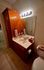 Cozy bathroom featuring elegant wooden cabinetry, a sleek countertop with a modern sink, and bright vanity lighting for a luxurious touch.