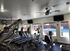 Modern fitness center featuring high-end exercise equipment with a pool view through large windows.