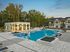Outdoor pool with covered patio and view of exterior of community