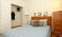 Inviting bedroom with a soft blue bedspread, wooden headboard, and stylish decor accents.