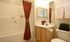 Elegant bathroom featuring a modern bathtub, sleek vanity, and warm decor.