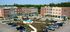 Charming apartment complex with a central fountain and ample parking surrounded by lush greenery.
