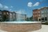 Elegant courtyard fountain with water jets surrounded by modern apartment buildings.