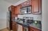 Modern kitchen featuring stainless steel appliances and elegant dark wood cabinetry.
