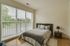 Bright and cozy bedroom with large windows, elegant bedding, and modern decor.