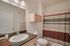 Sleek bathroom featuring modern lighting, a granite countertop, and a stylish striped shower curtain.
