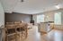 Spacious open-concept apartment with dining, living, and kitchen areas featuring wooden flooring and large windows.