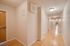 Bright and spacious hallway with polished wood flooring and modern lighting fixtures.