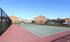 Inviting tennis court surrounded by well-maintained brick apartment buildings in a serene setting.