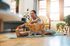 Bright living room with a woman practicing yoga on a mat, accompanied by a friendly cat.