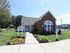 Inviting leasing office with red brick exterior and vibrant landscaping.