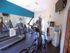 Bright fitness room featuring modern exercise equipment and a mirrored wall for an enhanced workout experience.