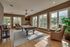 Bright lounge area featuring a pool table, stylish seating, and large windows with garden views.