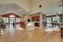 Spacious open living area with hardwood floors, a modern kitchen, and large windows providing natural light.