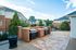 Inviting outdoor patio area with built-in brick grills and scenic view of apartment buildings.
