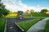 Beautifully landscaped playground with a wooden play structure and slide in a tranquil park setting.